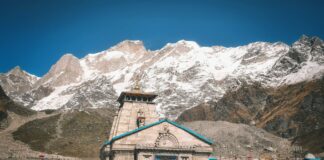 Pielgrzymi przed świątynią Kedarnath na tle ośnieżonych Himalajów