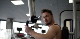Skupiony mężczyzna ćwiczy biceps na siłowni hotelowej