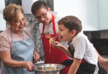 Babcia i wnukowie pieką razem w kuchni podczas rodzinnego weekendu