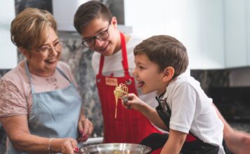 Babcia i wnukowie pieką razem w kuchni podczas rodzinnego weekendu