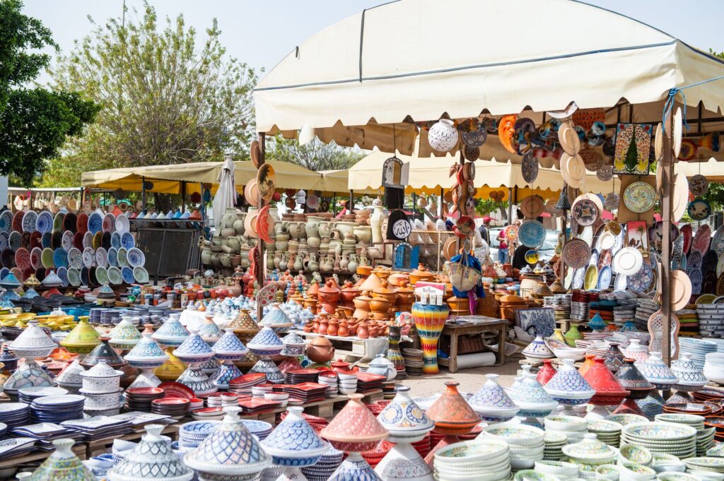 Stragany z kolorowymi tradycyjnymi naczyniami na miejskim bazarze w Maroku